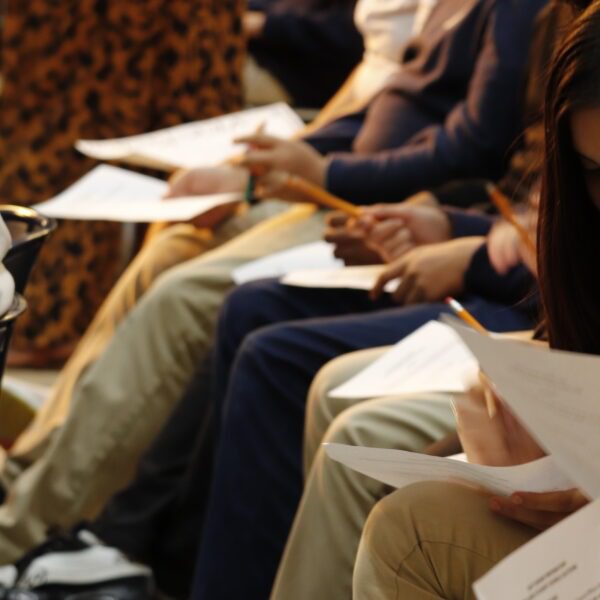 Line of students hold ballots to elect student council representatives.