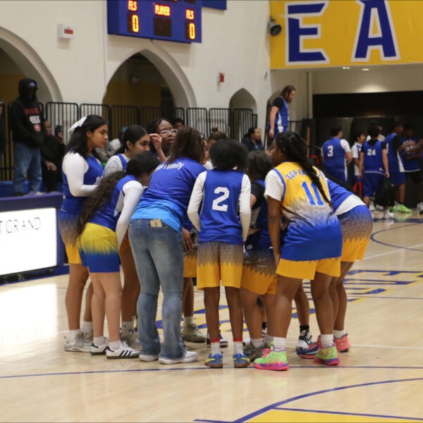 The Lady Eagles basketball team huddled during a game at East Grand Preparatory.